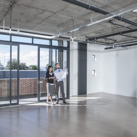 Businesspeople looking at construction plan in new open office