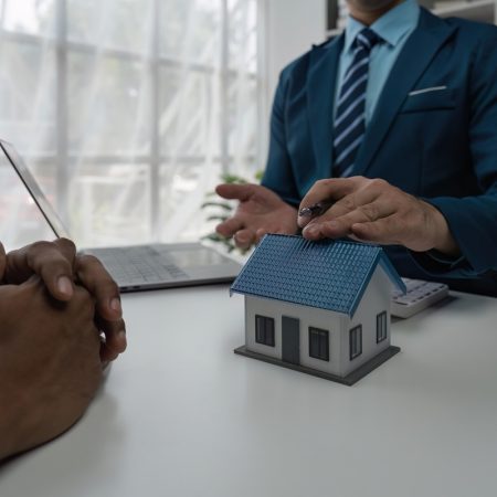 real estate agent holding house to his client after signing contract,concept for real estate, moving home or renting property.