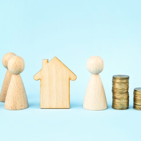 Wooden house and wooden little men on a blue background. Property division . Insurance concept, loans. Copy space. Banner.